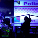 Seorang petugas polisi berjalan di sepanjang garis pembatas di lokasi penembakan massal di Pantai Bondi di Sydney, Australia, pada hari Minggu (Getty Images)