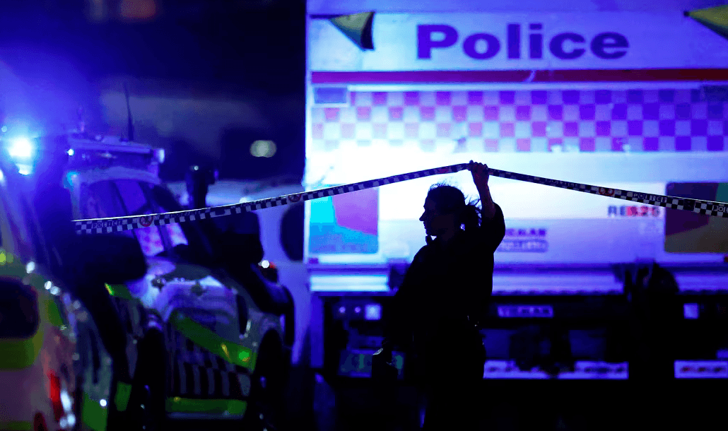 Seorang petugas polisi berjalan di sepanjang garis pembatas di lokasi penembakan massal di Pantai Bondi di Sydney, Australia, pada hari Minggu (Getty Images)
